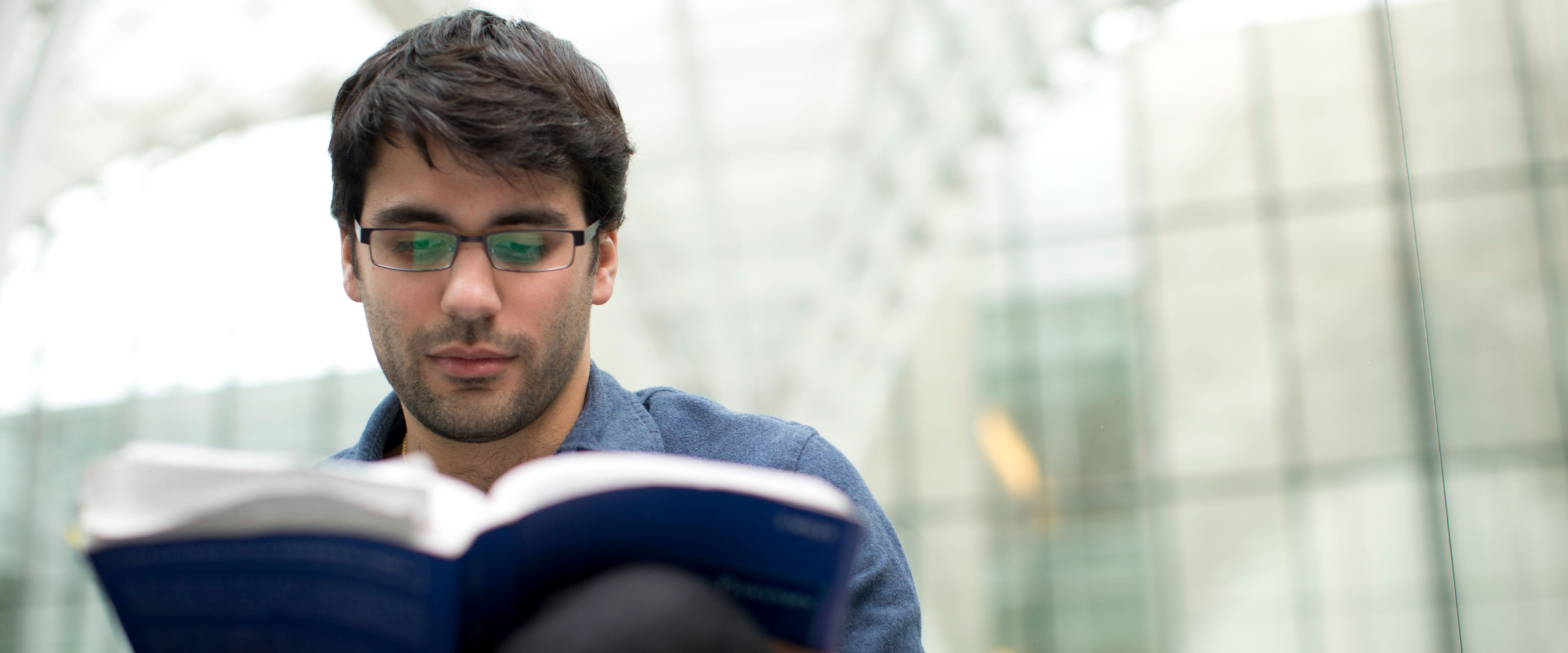 Male student reading a textbook