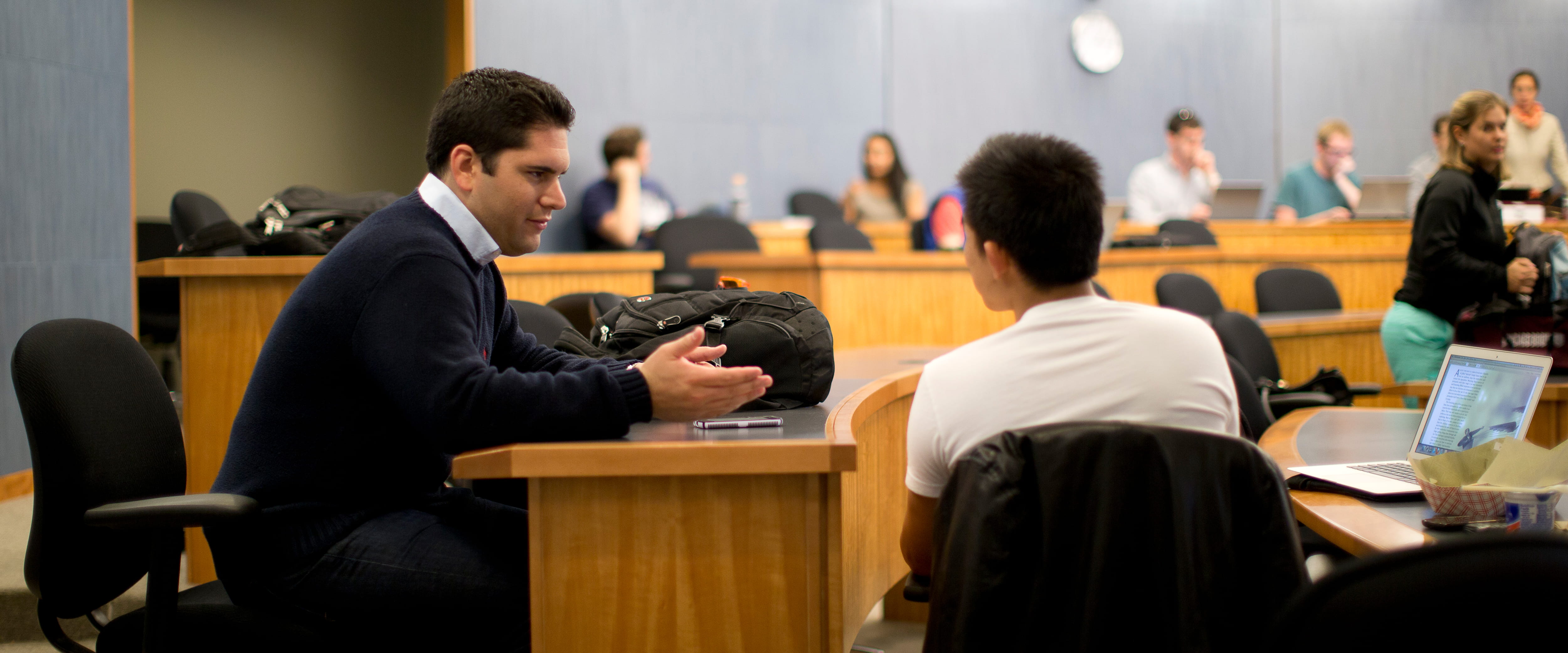 Two male students sitting in a classroom, collaborating