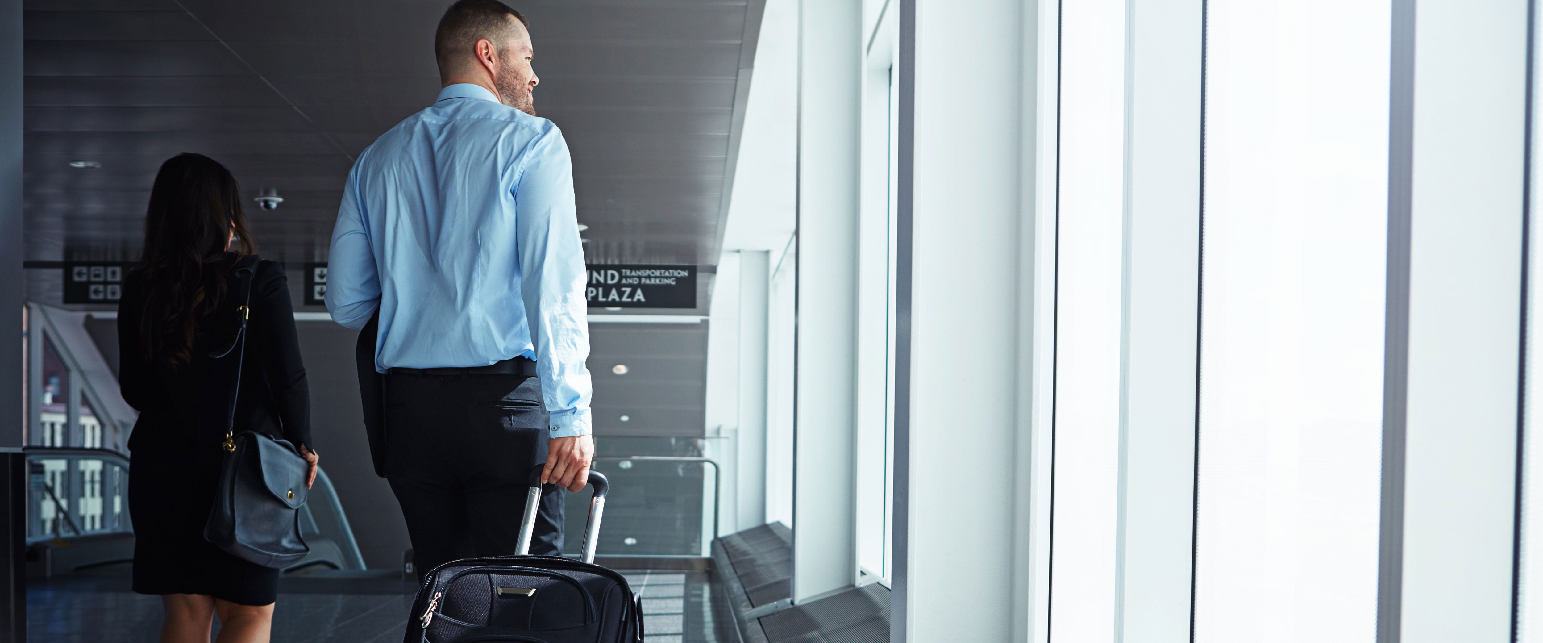 Male and female students walking in an airport