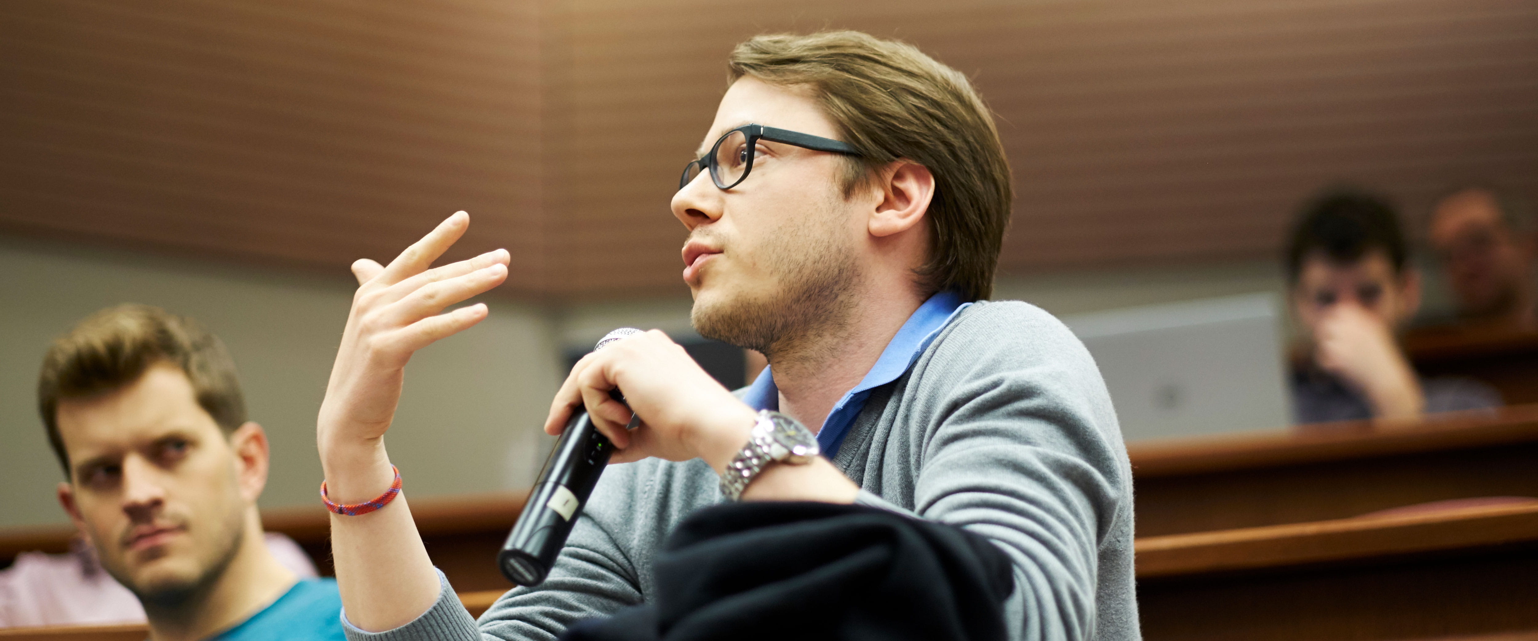 Female student at an event, speaking into a microphone