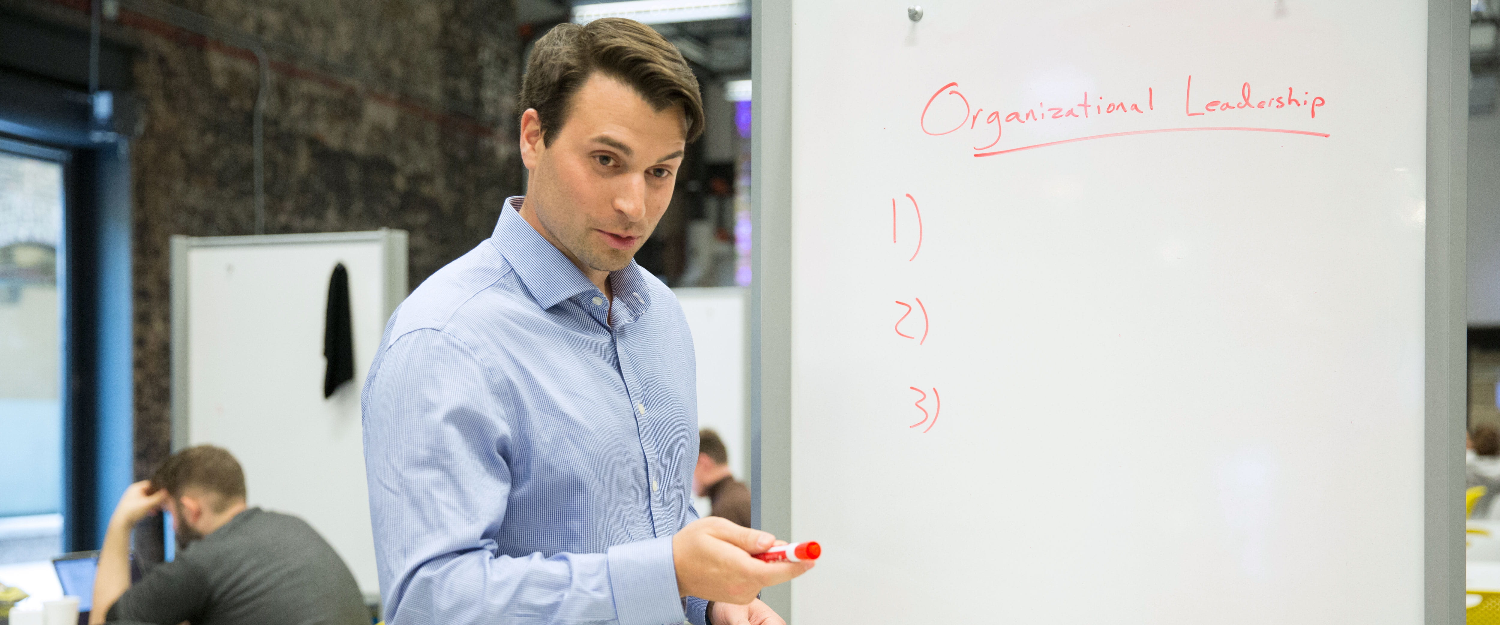 Male alumnus leading a meeting at work