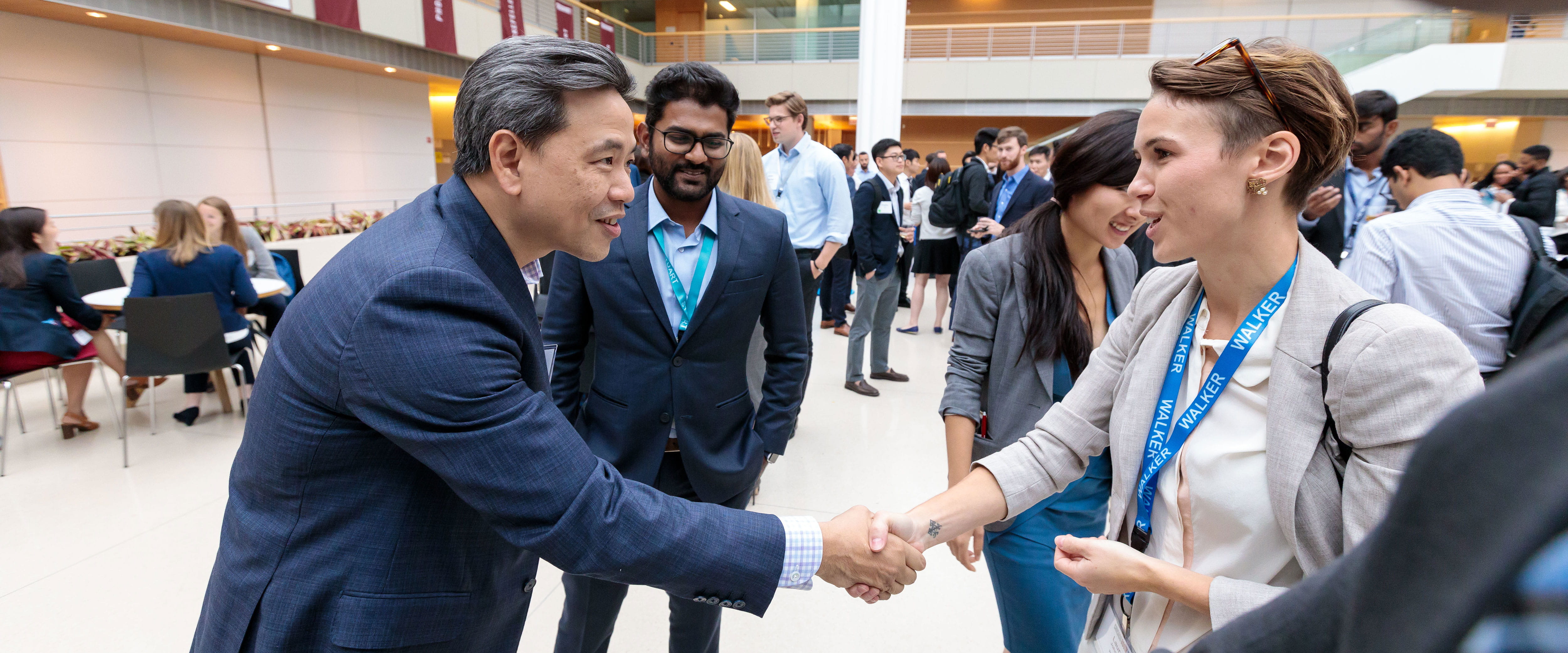 Chicago Booth female student shaking hands with alumni