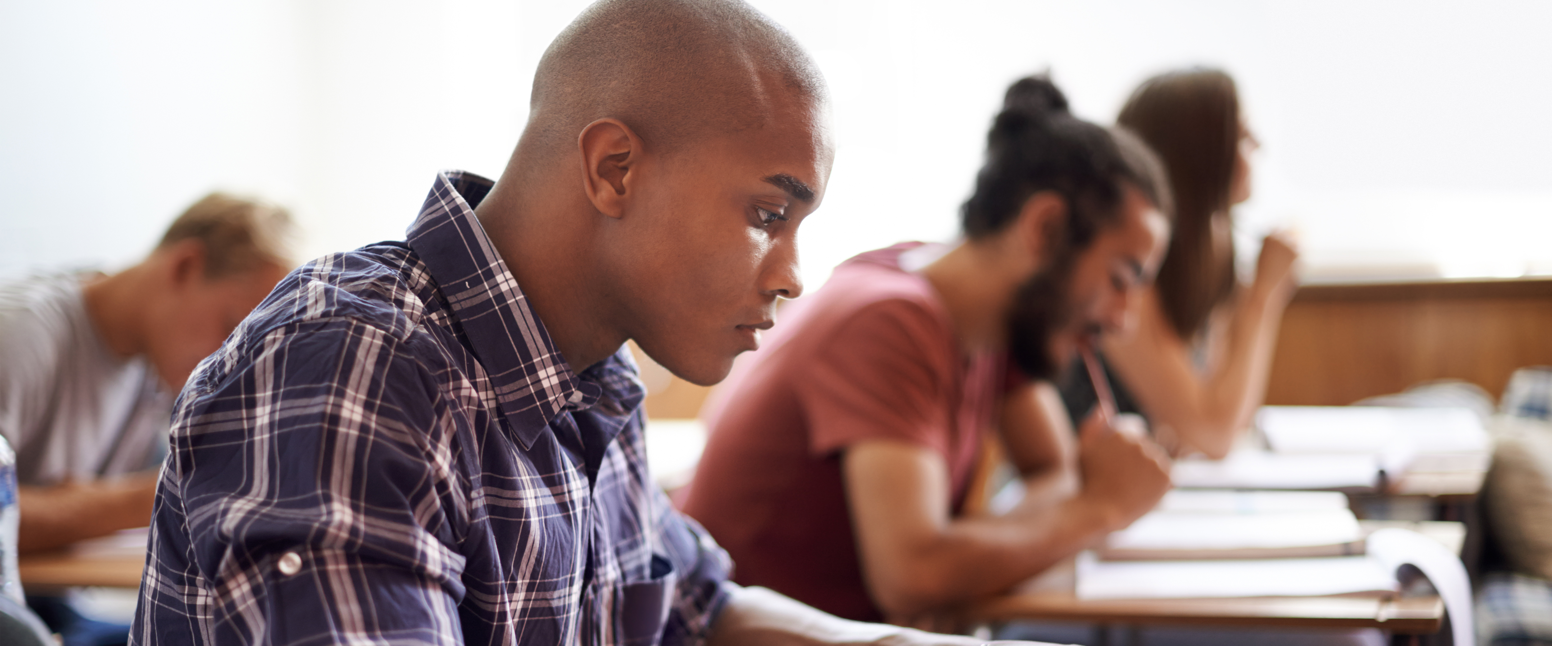 A male student takes notes in class