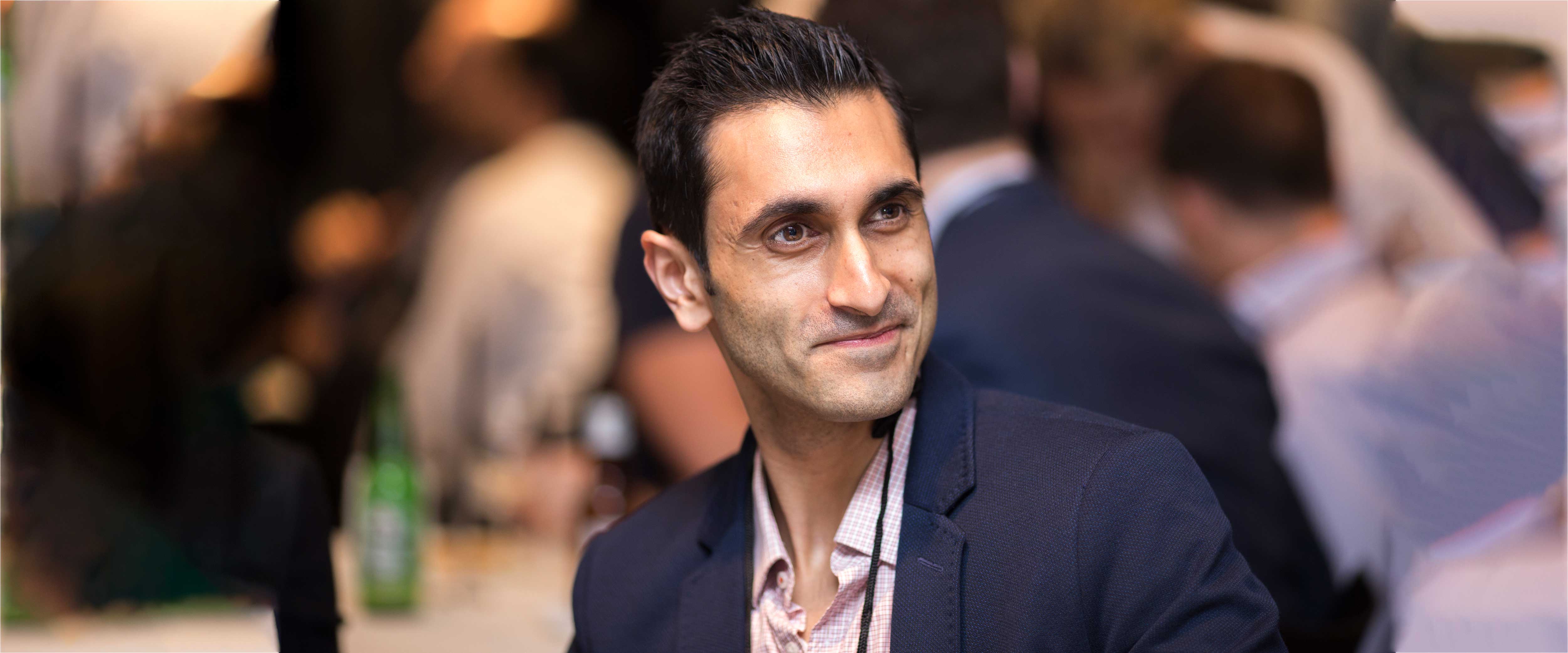 Man sitting at a table and smiling at an event