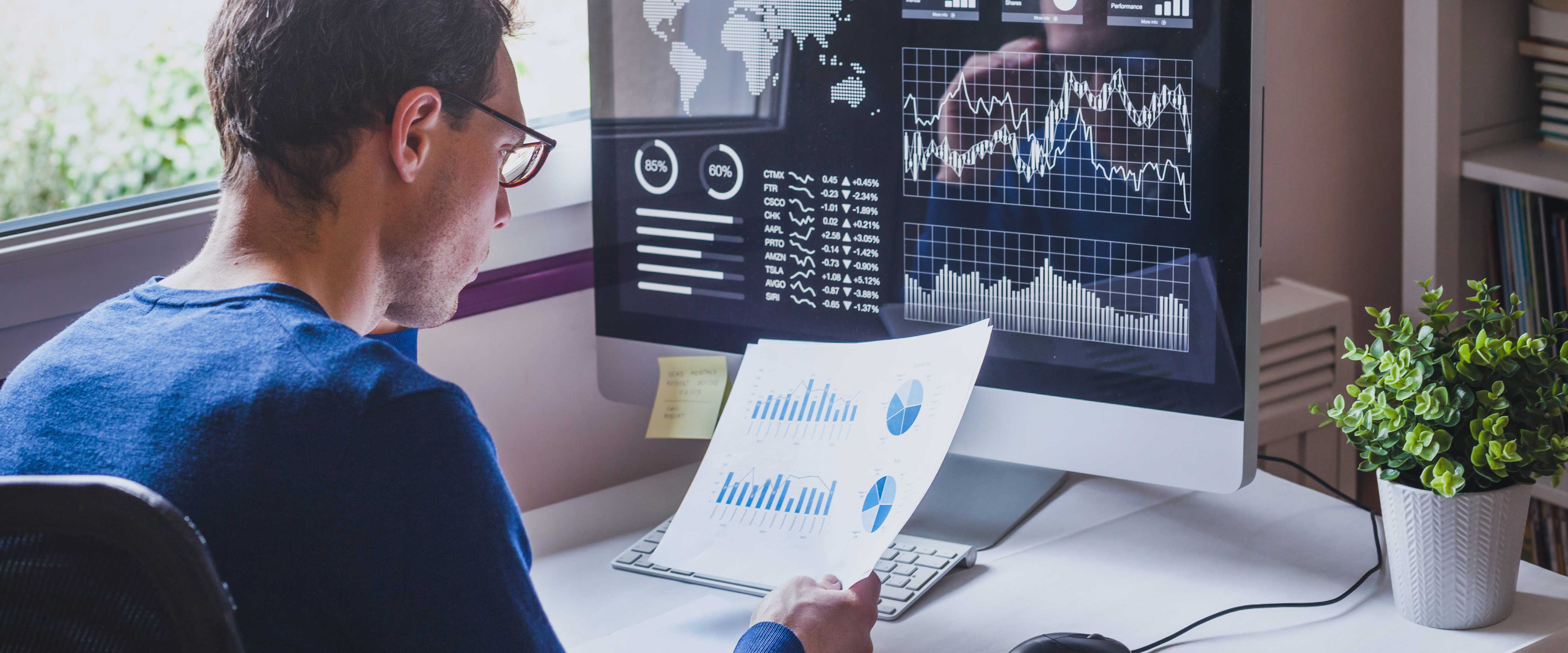 Woman in the Chicago Booth winter garden working on a red laptop
