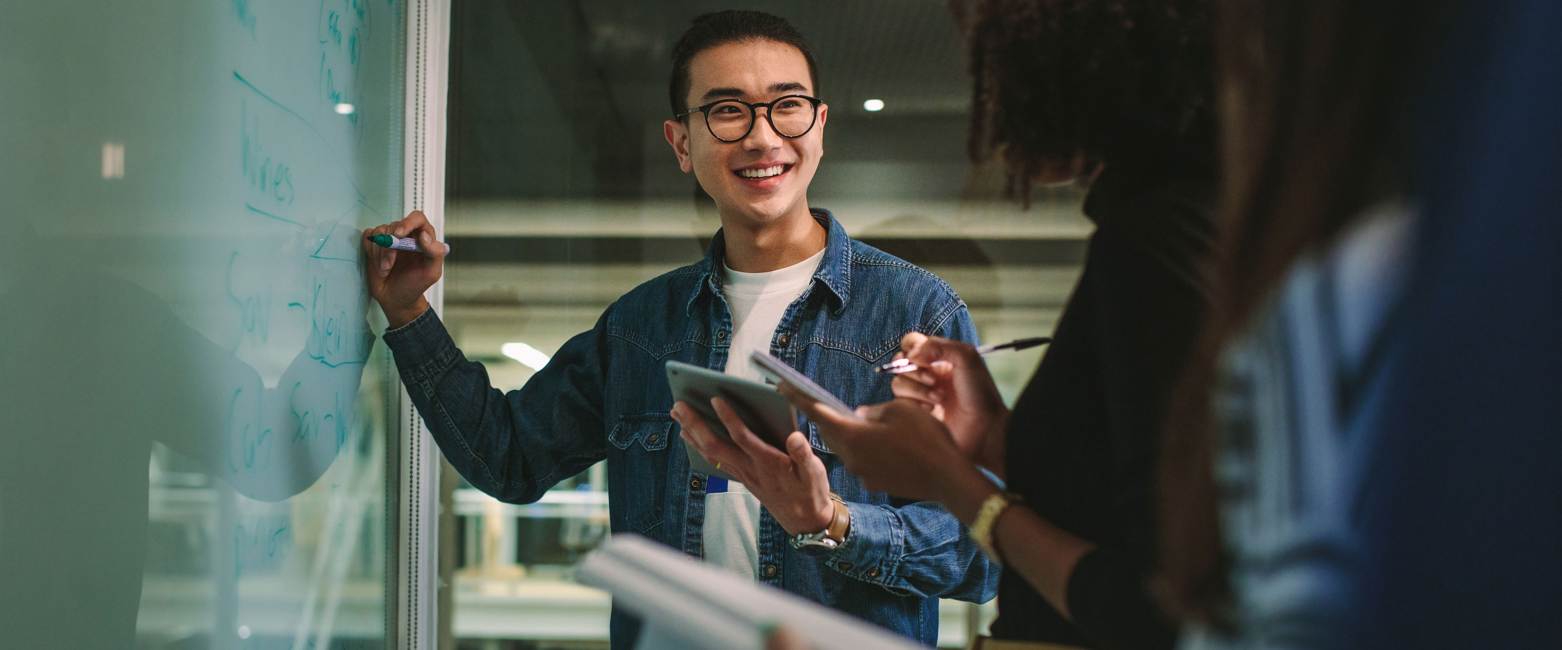Young man at the white board smiling