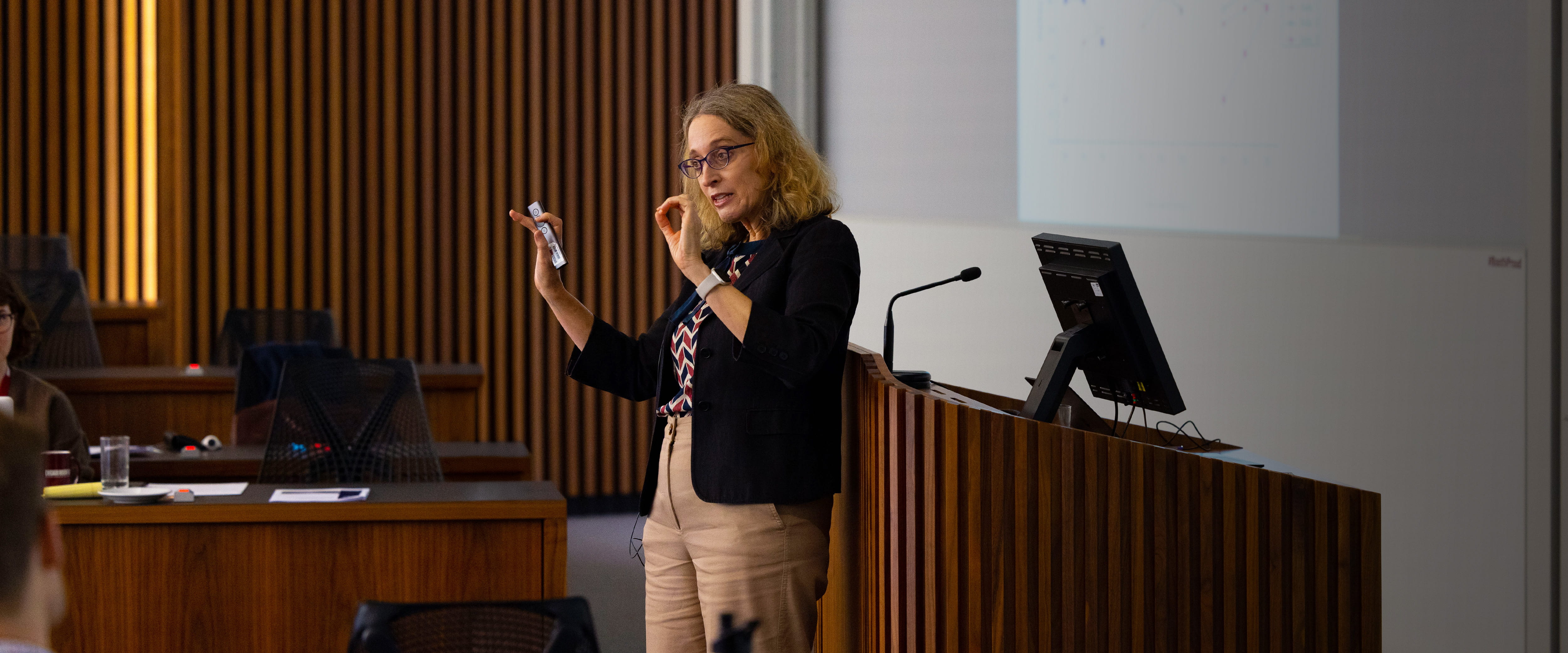 Professor Ayelet Fishbach gestures with her hands while teaching and lecturing a class. 