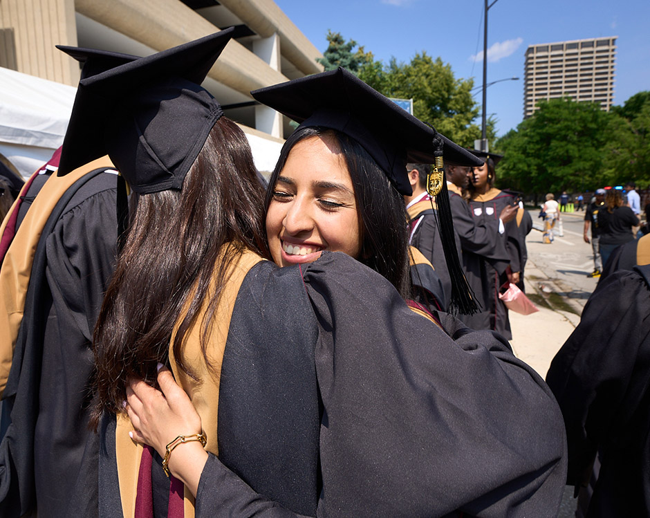 Two graduates hug.