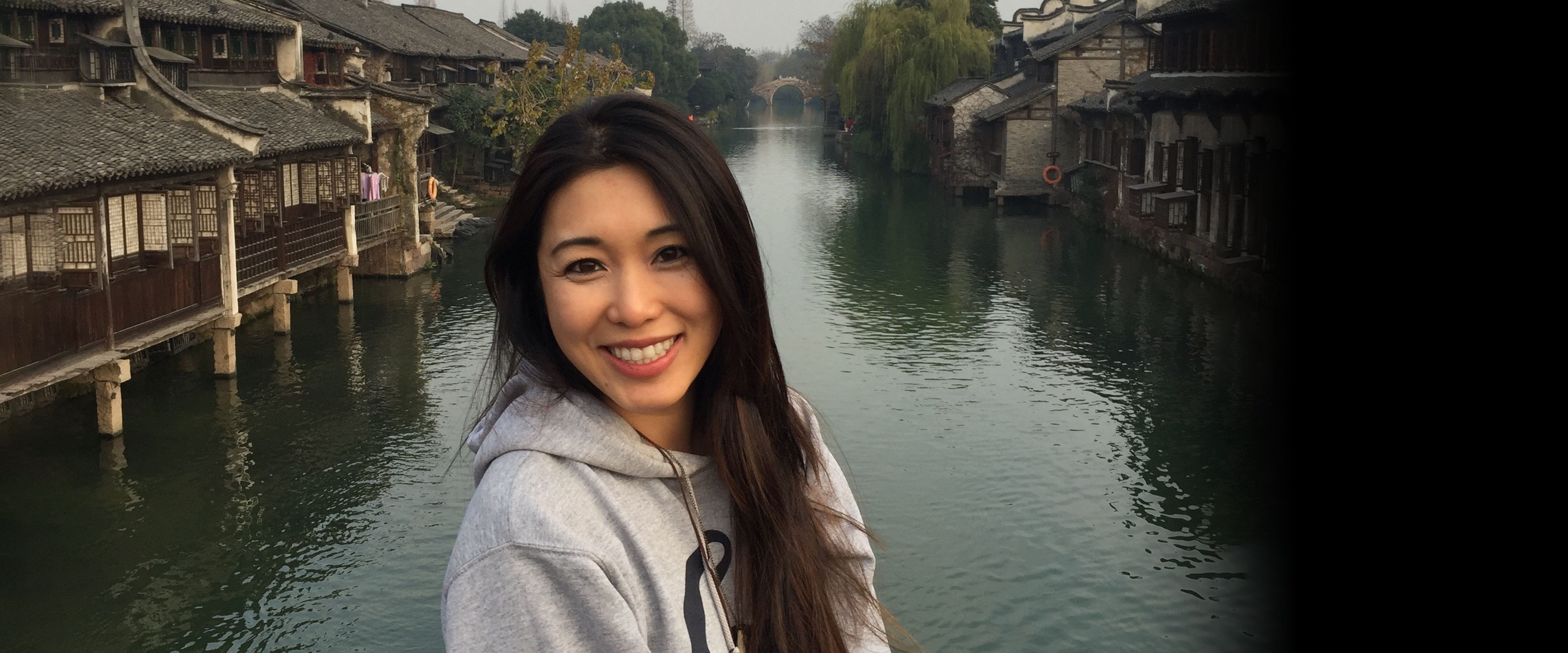 Full time MBA graduate Lily Xu, ’13 posing in front of a river 
