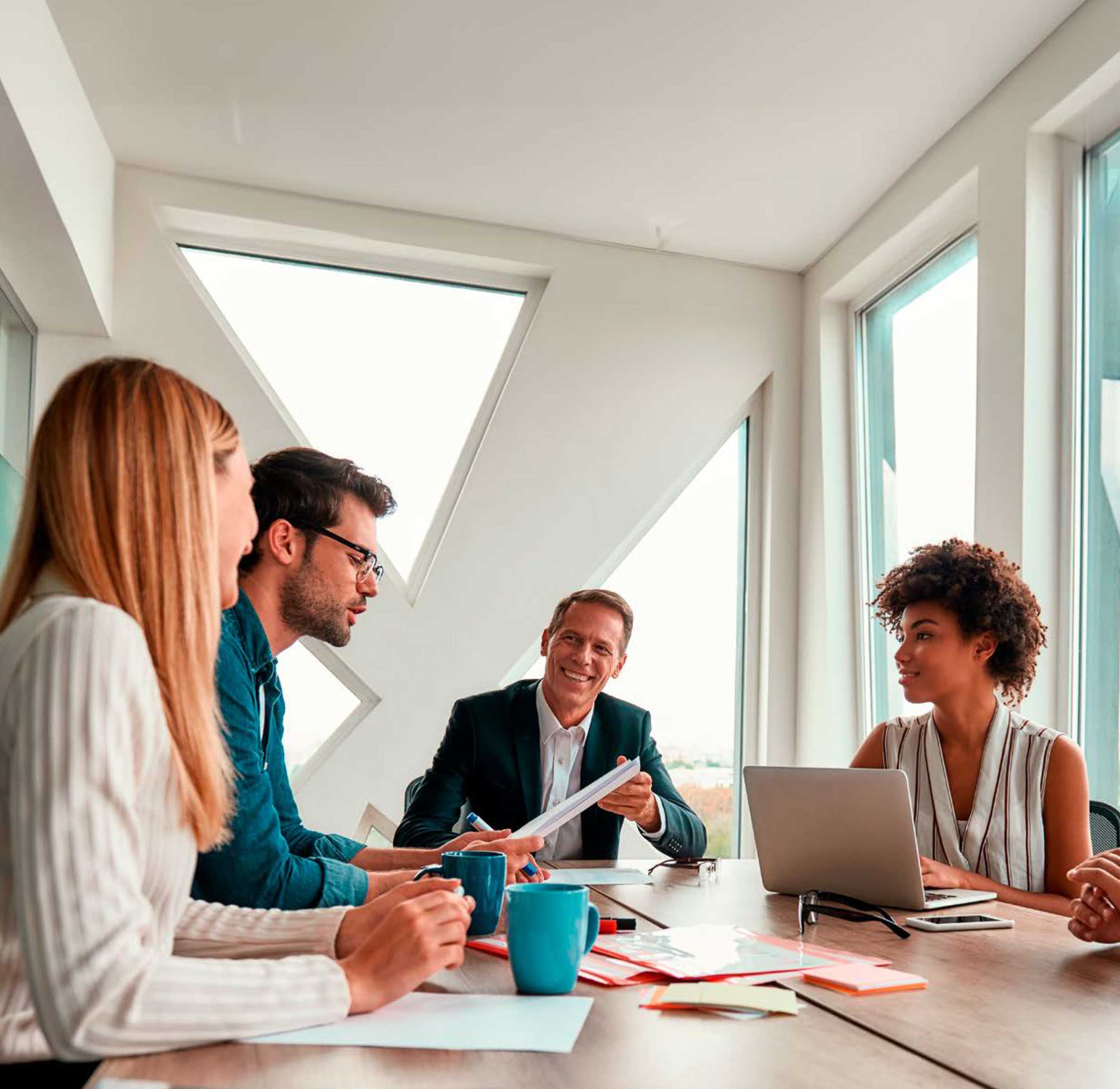 Four people working in a conference room together